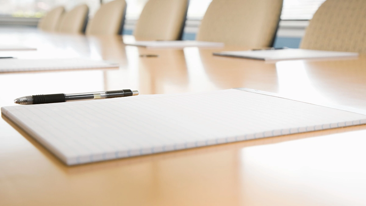 Blöcke und Stifte liegen bereit auf einem unbesetzten Konferenztisch