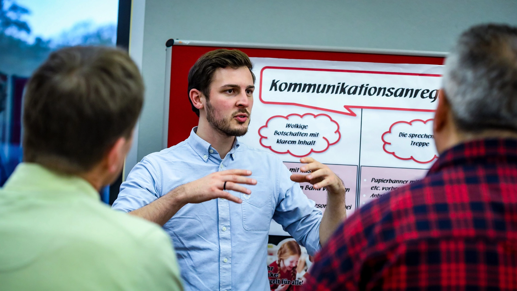 Junger Mann steht vor Flipchart und erklärt etwas.