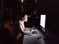 Geschäftsfrau vor Computer-Bildschirm im Büro in der Nacht